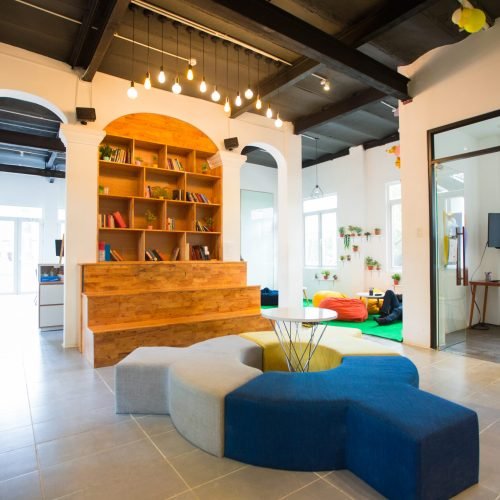Modern interior of lobby with uncommon furniture and line of luminous electric light bulbs above wooden bench. Arches separated big space. Waiting room concept